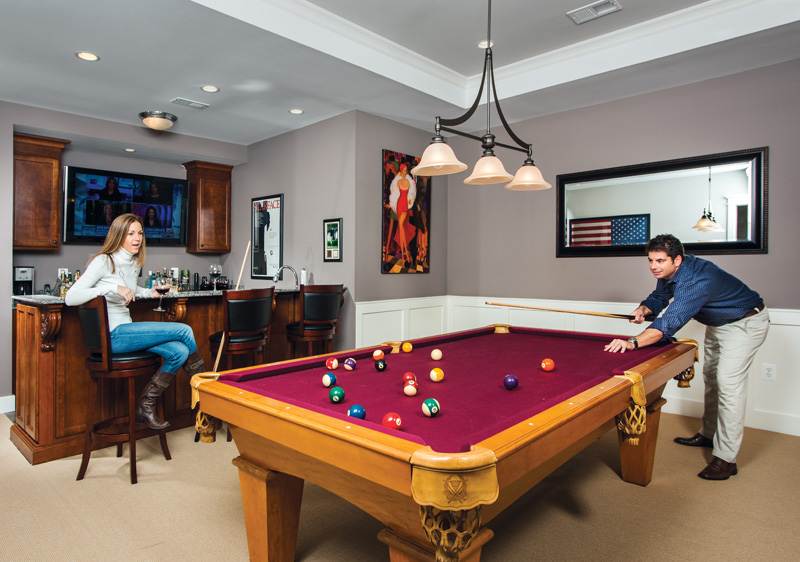 Movie posters, vintage prints and an old-time popcorn maker complete the theme of the DeFalcos’ lower-level entertainment zone. Photo by Darren S. Higgins